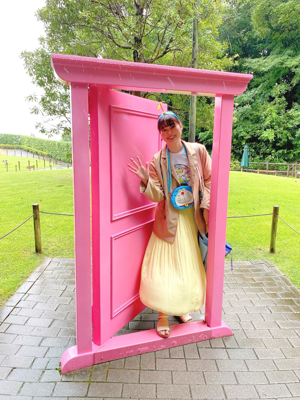 ホワイト系のTシャツ/カットソー、ベージュ系のピーコート、イエロー系のスカートを着用したレディースの秋コーディネートの1枚目の写真