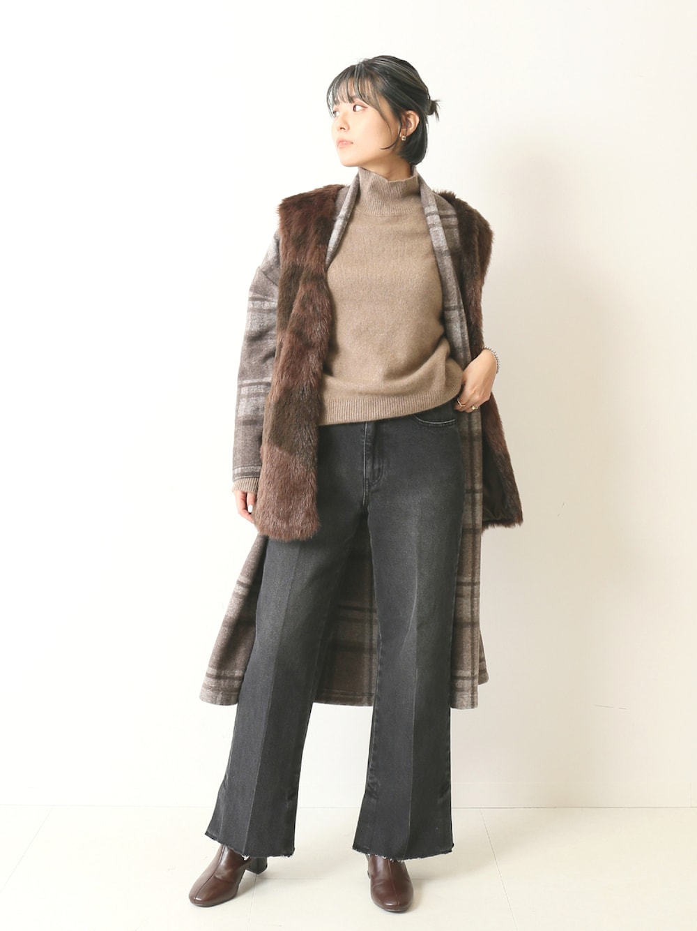 ブラウン系のその他アウター、ブラウン系のニット/セーター、グレー系のデニムパンツを着用したレディースの秋コーディネートの1枚目の写真