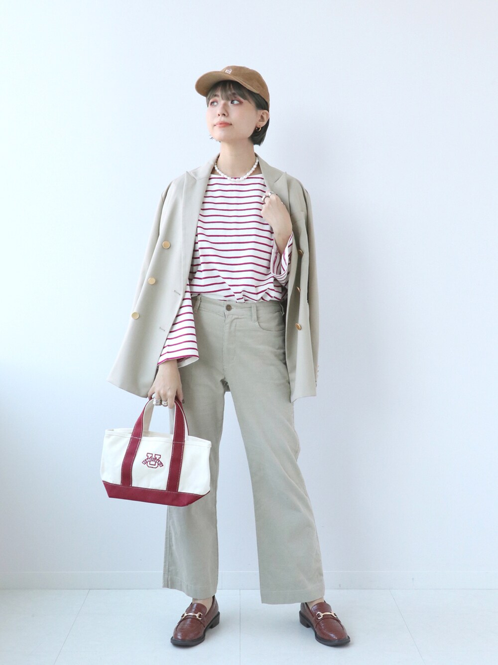 ピンク系のTシャツ/カットソー、ベージュ系のその他アウター、ブラウン系のローファーを着用したレディースの秋コーディネートの1枚目の写真
