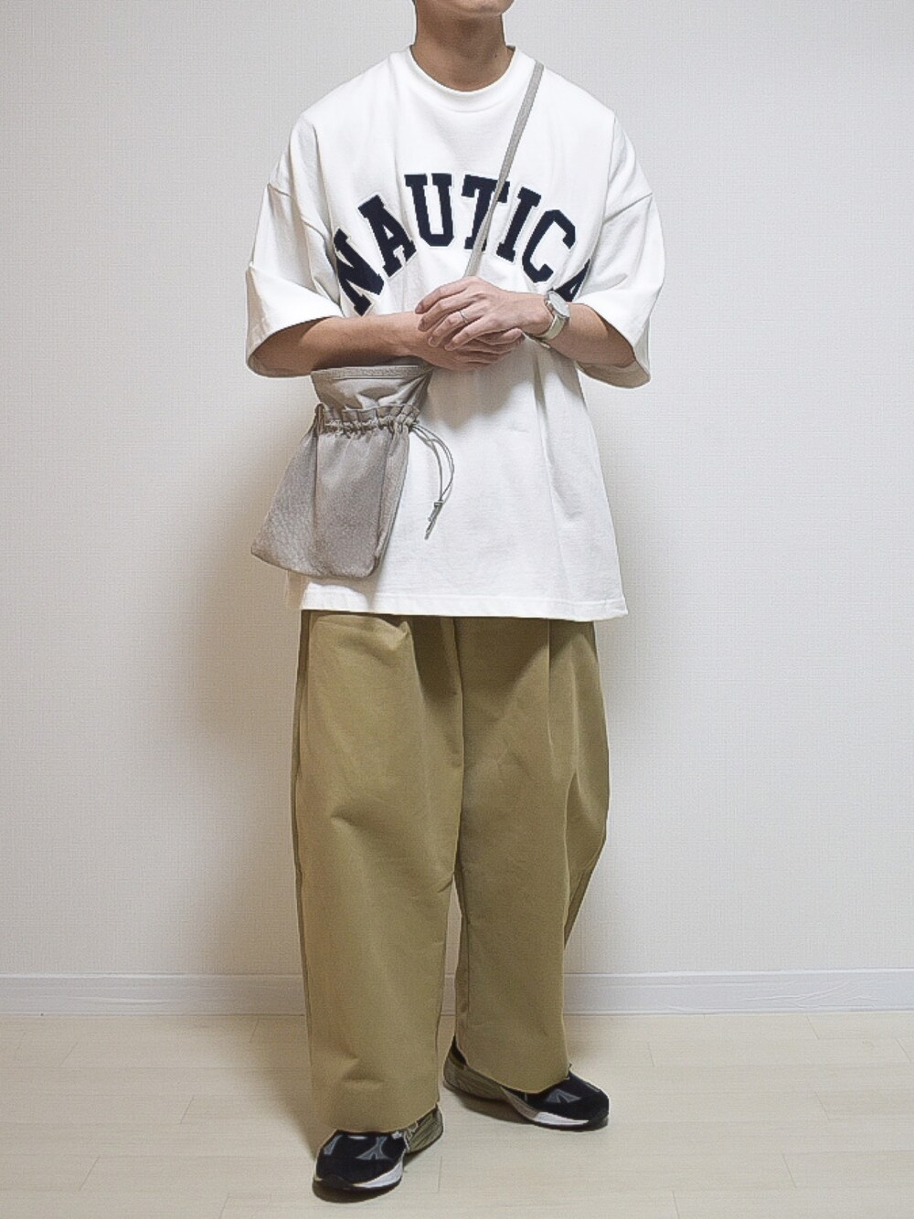 ホワイト系のTシャツ/カットソー、ベージュ系のその他パンツ、ブラック系のシューズを着用したメンズの春コーディネートの1枚目の写真