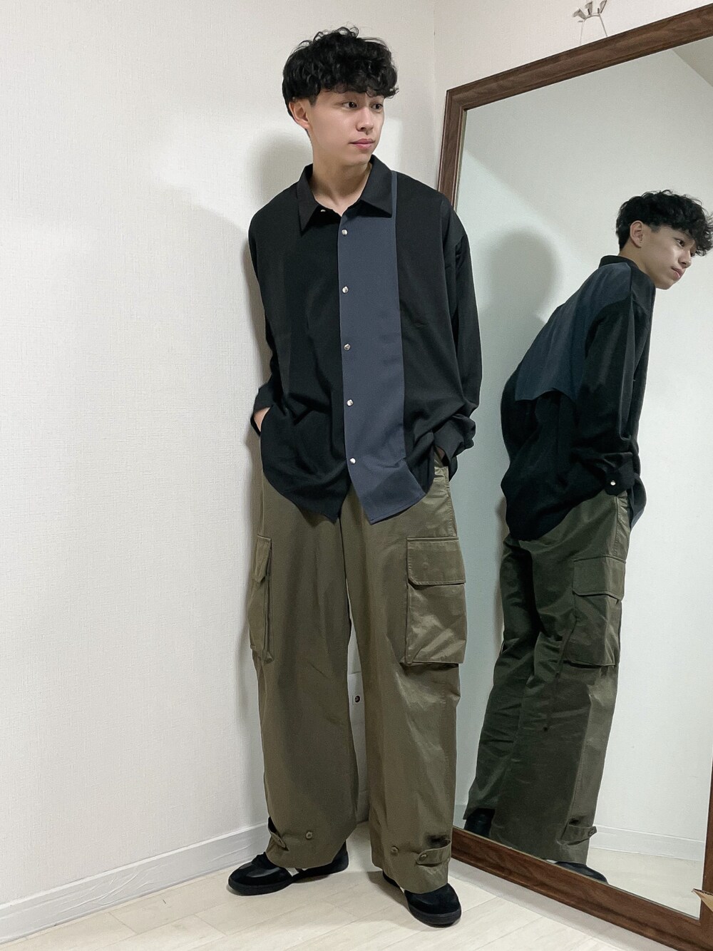 ブラック系のシャツ/ブラウス、グリーン系のカーゴパンツ、ブラック系のスニーカーを着用したメンズの春コーディネートの1枚目の写真