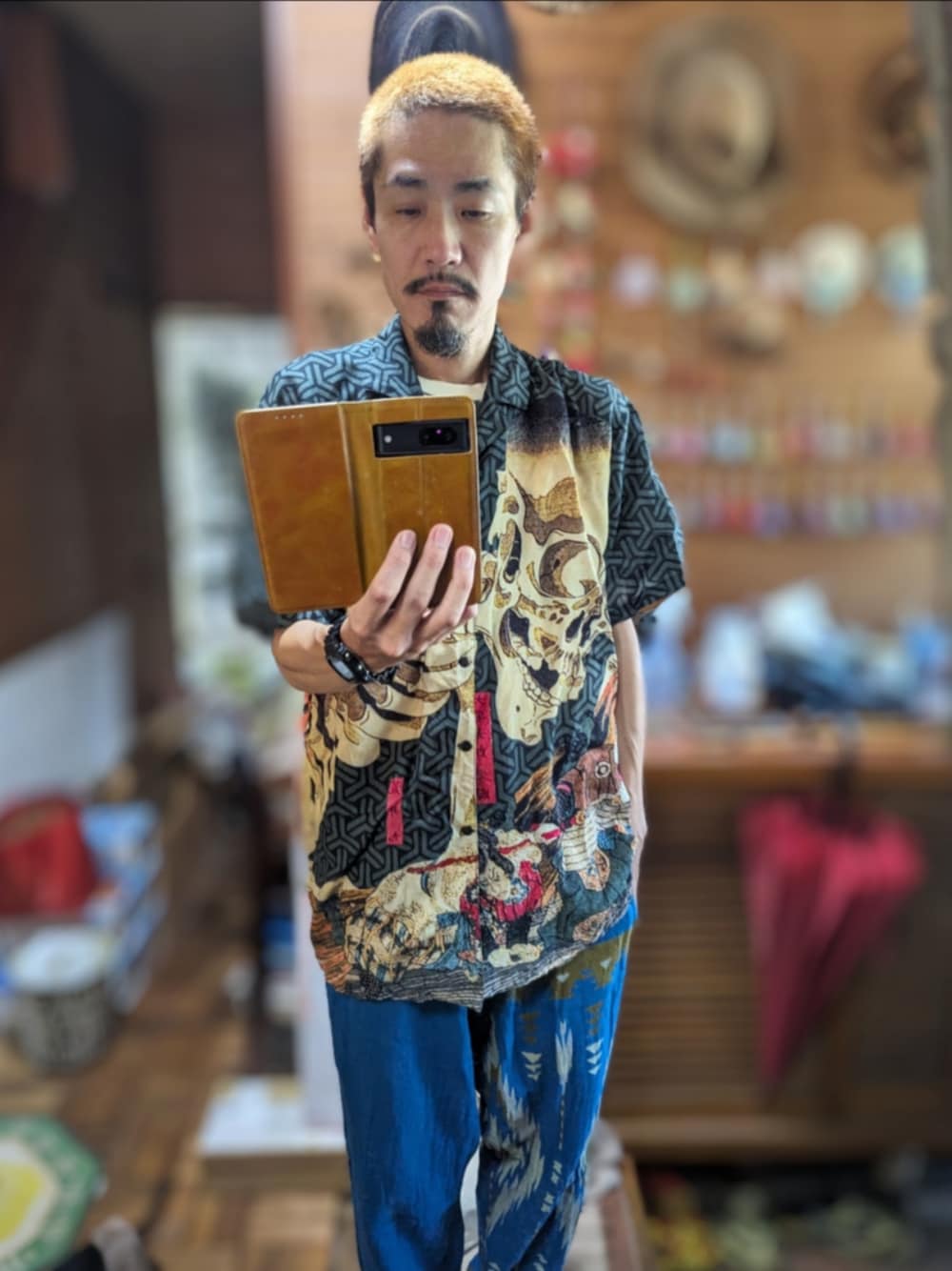 「ootd、今日のコーデ、おしゃれさんと繋がりたい、古着好きな人と繋がりたい、倭物やカヤ、スカル、シャツスタイル、レーヨンシャツ、チャイハネ、イージーパンツ、ネイティブ柄、金髪、ヒゲ、g shock、古着屋」｜「倭物やカヤのアイテム（シャツ/ブラウス、ブラック系）」を使った、 Beatnik BeaTの中の人さん（メンズ・175cm）の夏コーディネートの1枚目の写真