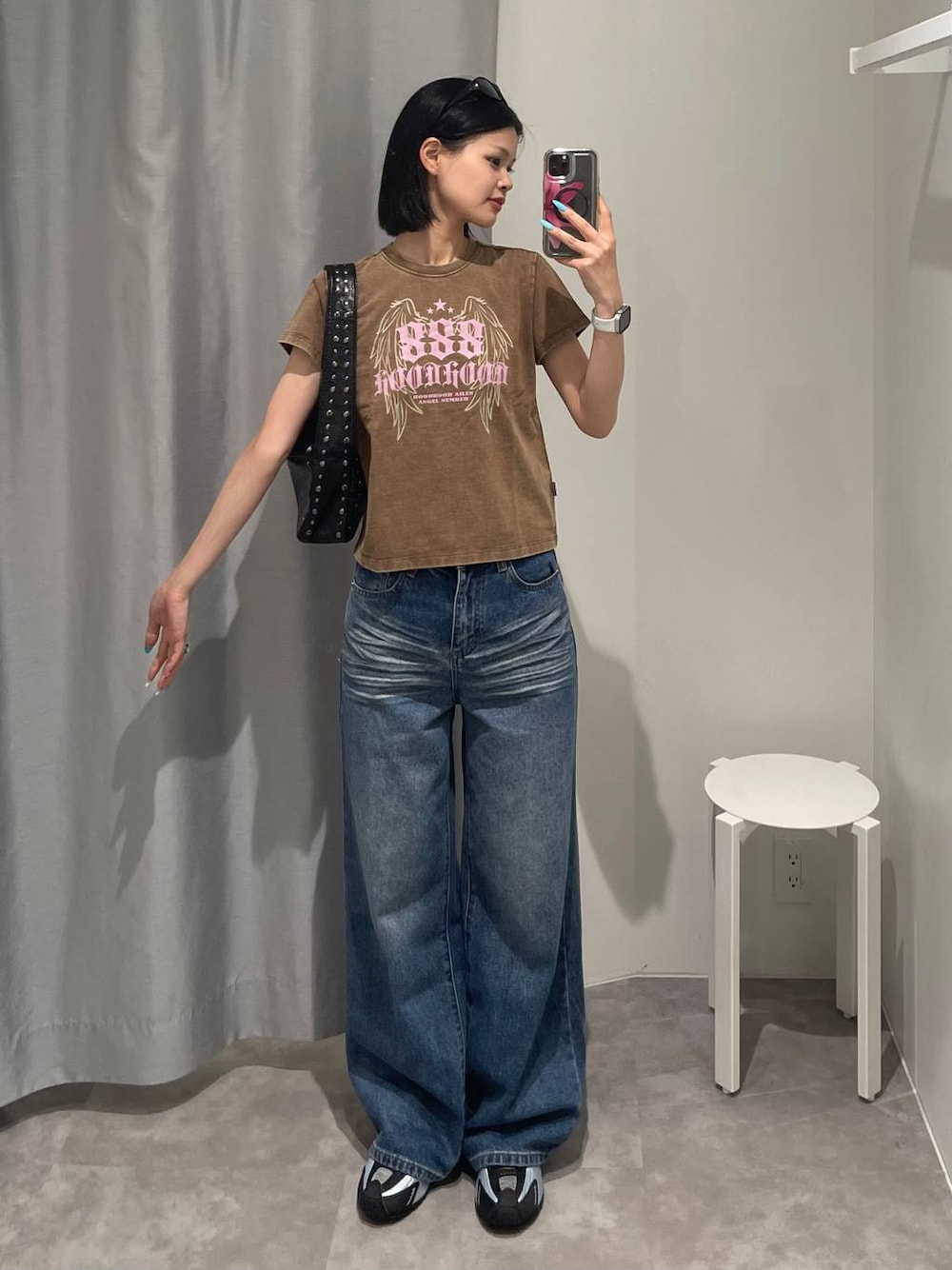 ブルー系のデニムパンツ、ブラック系のハンドバッグ、ブラック系のサングラスを着用したレディースの夏コーディネートの1枚目の写真