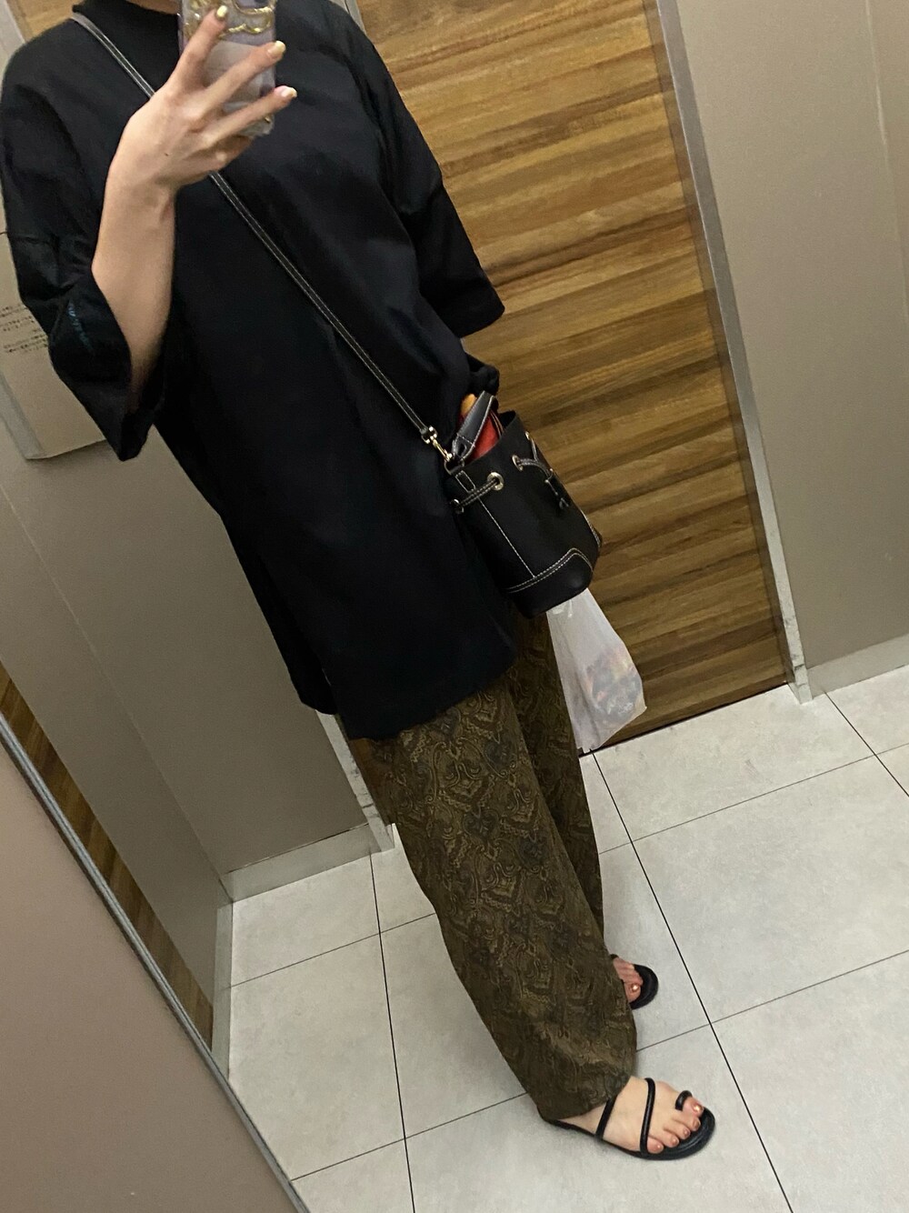 ブラック系のTシャツ/カットソー、ブラウン系のその他パンツ、ブラック系のサンダルを着用したレディースの秋コーディネートの1枚目の写真