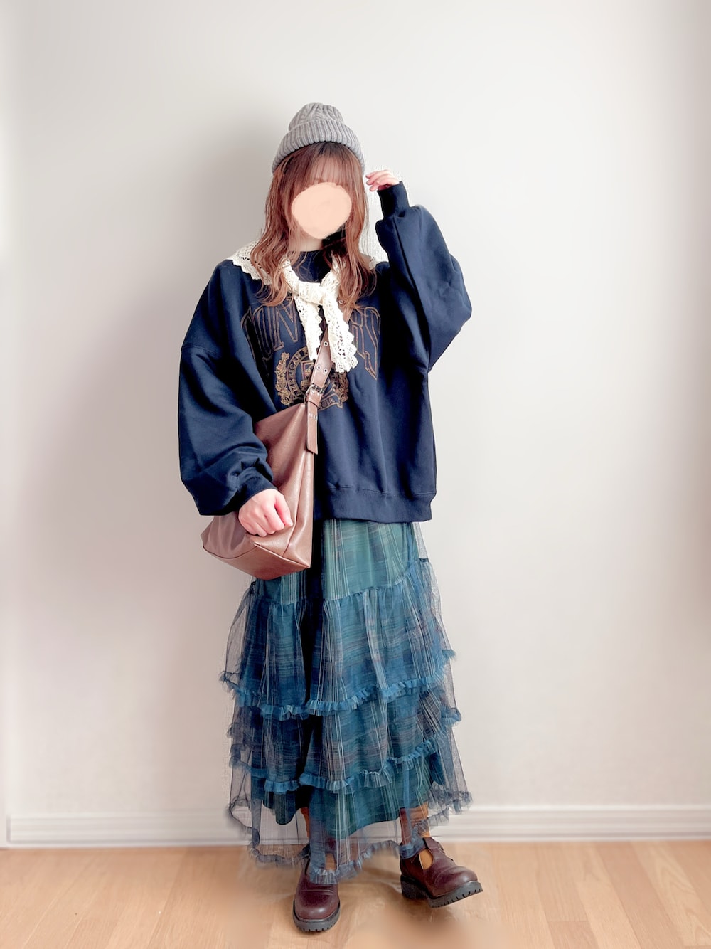 ブルー系のスウェット、グリーン系のスカート、ブラウン系のショルダーバッグを着用したレディースの冬コーディネートの1枚目の写真