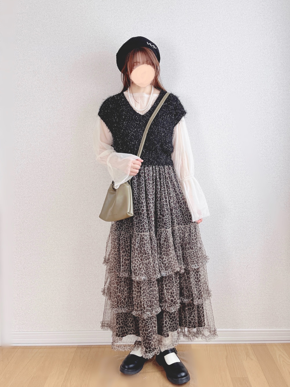 ブラック系のベスト、ホワイト系のTシャツ/カットソー、ベージュ系のスカートを着用したレディースの秋コーディネートの1枚目の写真