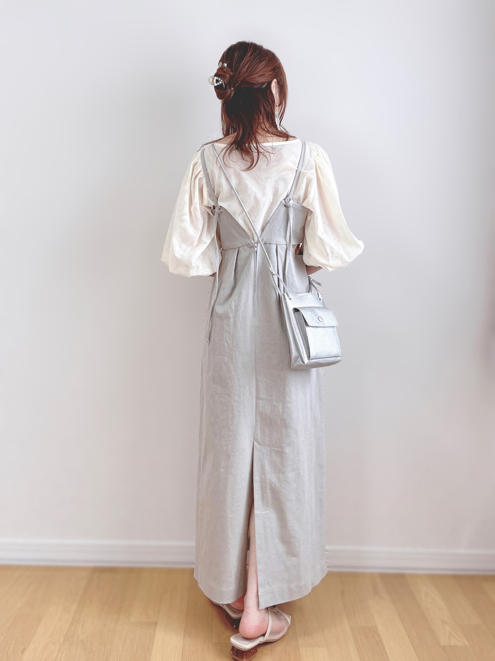 グレー系のワンピース、シルバー系のショルダーバッグ、ベージュ系のサンダルを着用したレディースの夏コーディネートの1枚目の写真