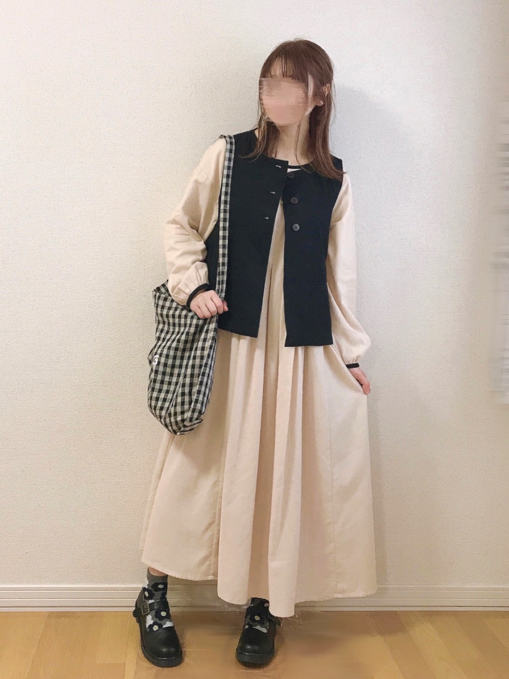 ホワイト系のワンピース、ブラック系のベスト、ブラック系のその他シューズを着用したレディースの春コーディネートの1枚目の写真