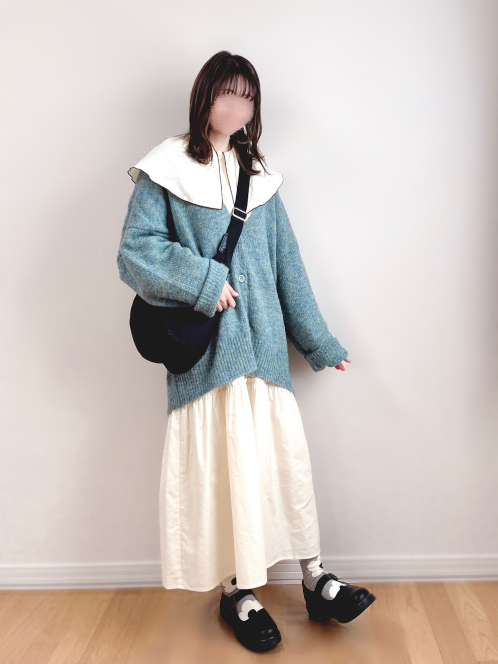 ホワイト系のワンピース、グリーン系のカーディガン/ボレロ、ブラック系のショルダーバッグを着用したレディースの秋コーディネートの1枚目の写真