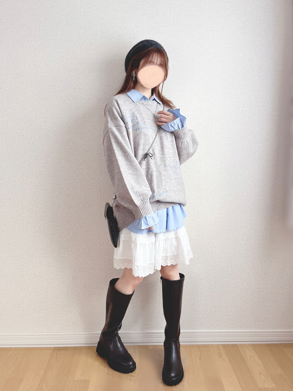 グレー系のニット/セーター、ブルー系のシャツ/ブラウス、ホワイト系のスカートを着用したレディースの春コーディネートの1枚目の写真