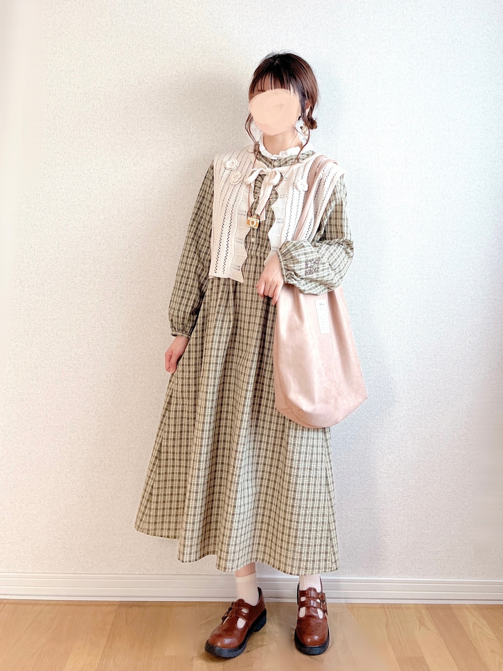 グリーン系のワンピース、ホワイト系のベスト、ベージュ系のトートバッグを着用したレディースの秋コーディネートの1枚目の写真