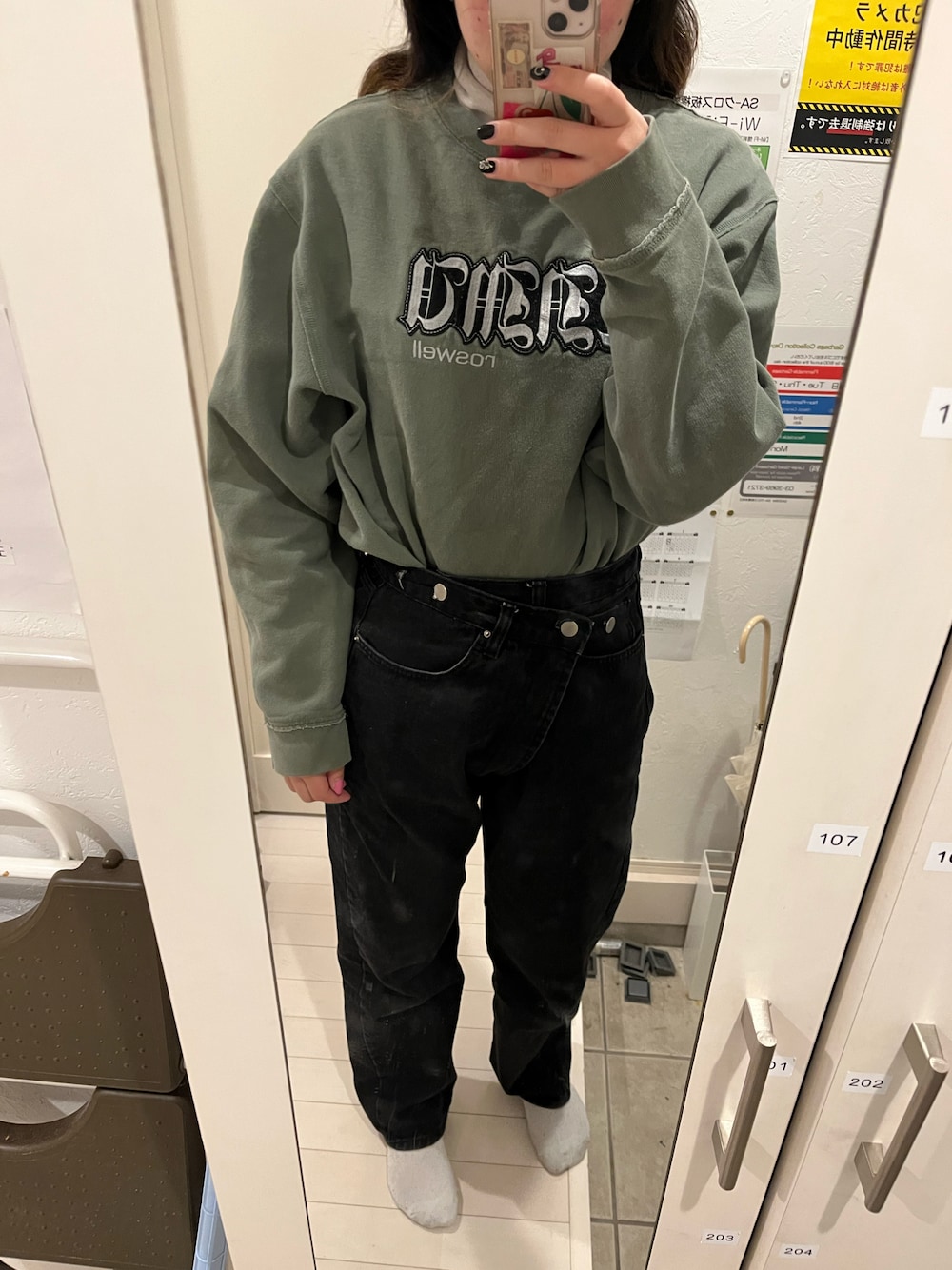 ブラック系のトップス、グリーン系のスウェット、ブラック系のデニムパンツを着用したレディースの冬コーディネートの1枚目の写真