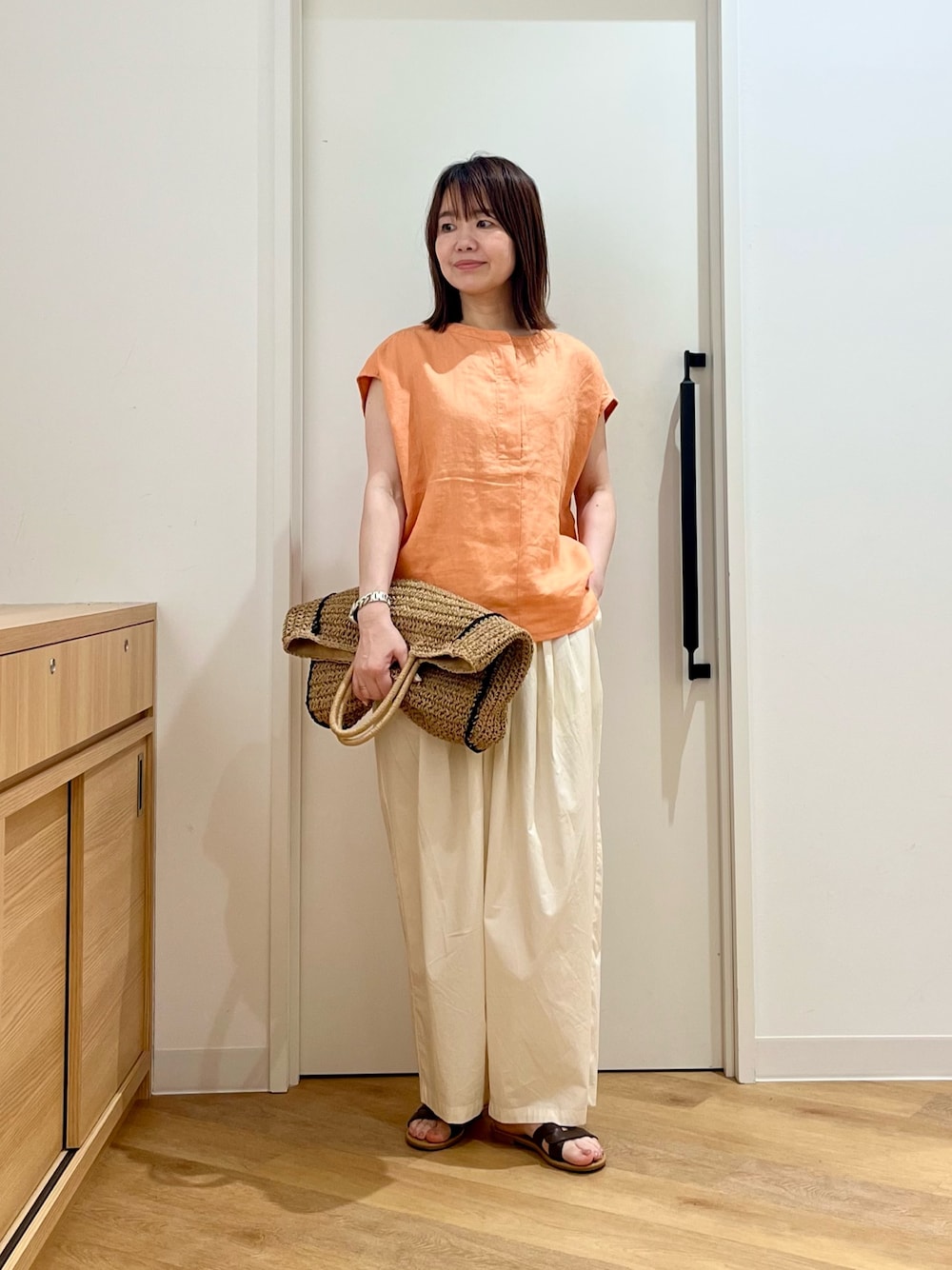 ベージュ系のトートバッグ、ホワイト系のその他パンツ、ブラウン系のサンダルを着用したレディースの夏コーディネートの1枚目の写真