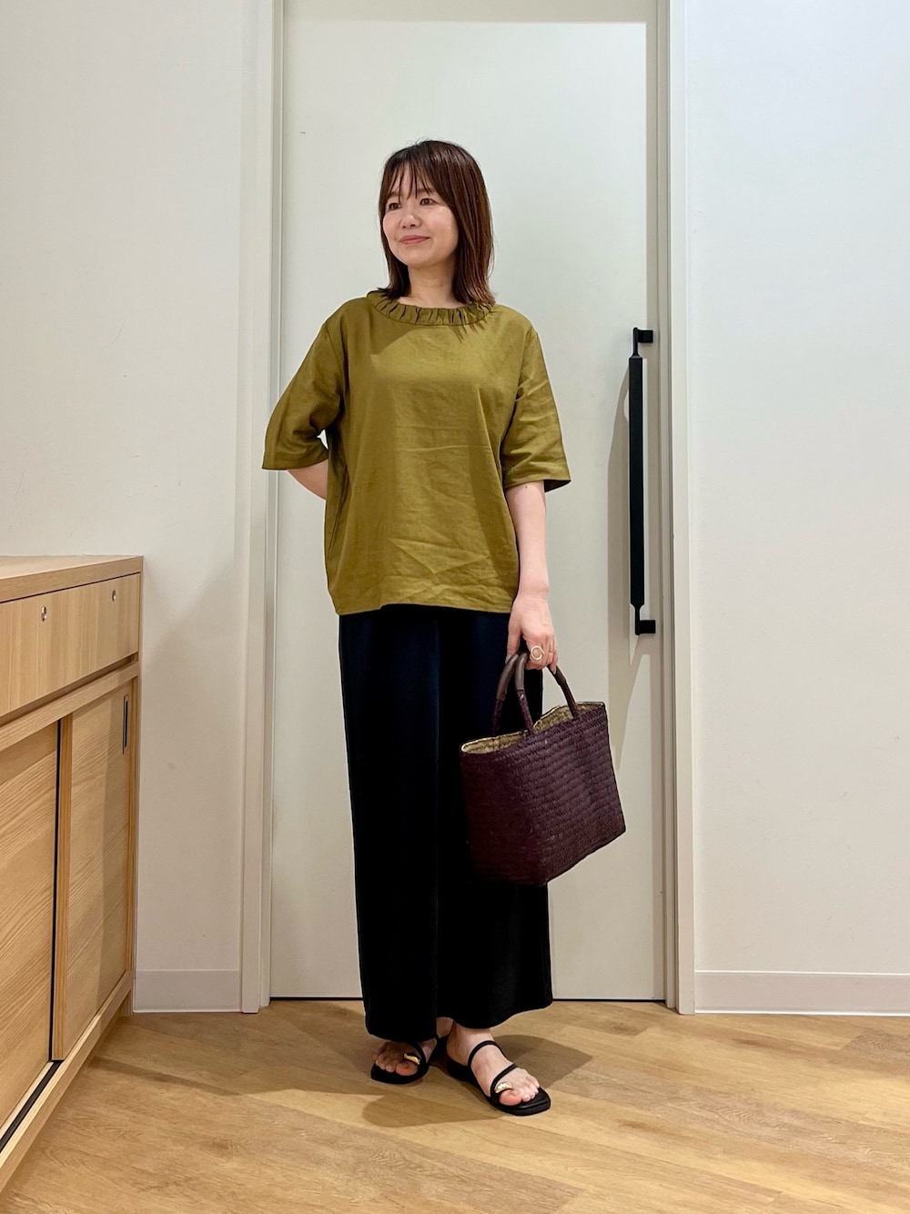 イエロー系のシャツ/ブラウス、ブラウン系のトートバッグ、ブラック系のスカートを着用したレディースの夏コーディネートの1枚目の写真
