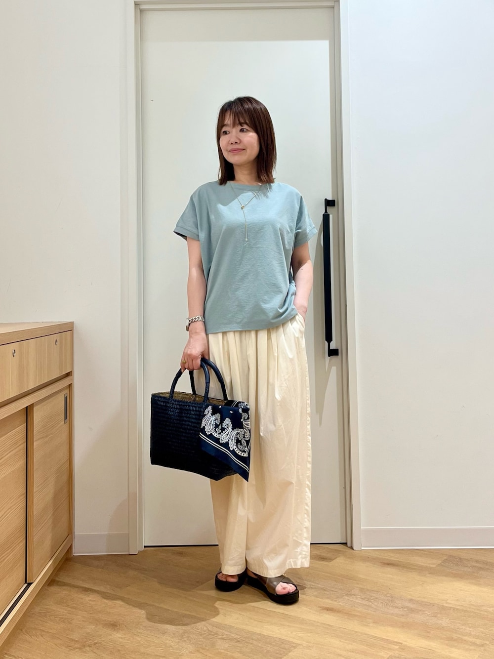 グリーン系のTシャツ/カットソー、ホワイト系のその他パンツ、ブルー系のトートバッグを着用したレディースの夏コーディネートの1枚目の写真