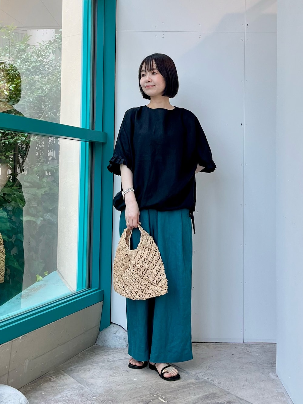 ブラック系のシャツ/ブラウス、ブルー系のその他パンツ、ベージュ系のハンドバッグを着用したレディースの夏コーディネートの1枚目の写真