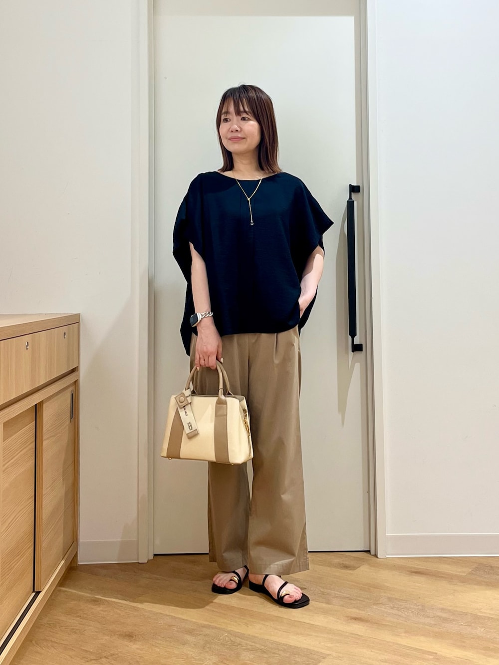 ブルー系のシャツ/ブラウス、ベージュ系のその他パンツ、ホワイト系のハンドバッグを着用したレディースの夏コーディネートの1枚目の写真