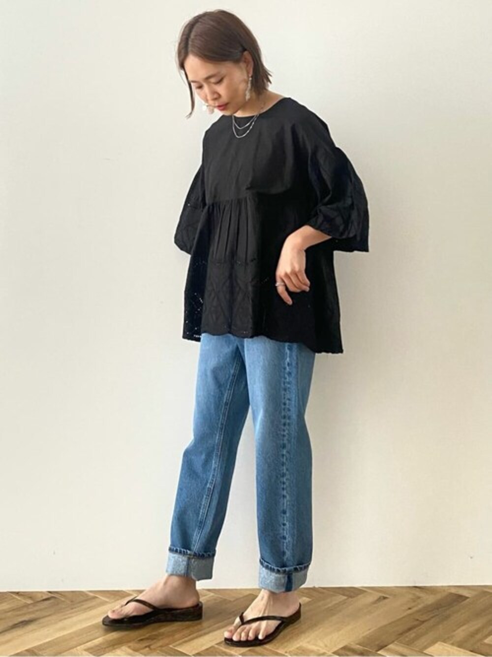 ブラック系のシャツ/ブラウス、ブルー系のデニムパンツを着用したレディースの春コーディネートの1枚目の写真