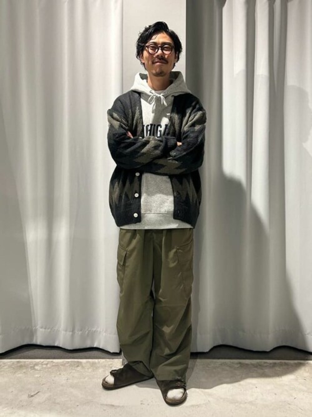ブラック系のカーディガン/ボレロ、グレー系のTシャツ/カットソー、グリーン系のカーゴパンツを着用したレディースの冬コーディネートの1枚目の写真