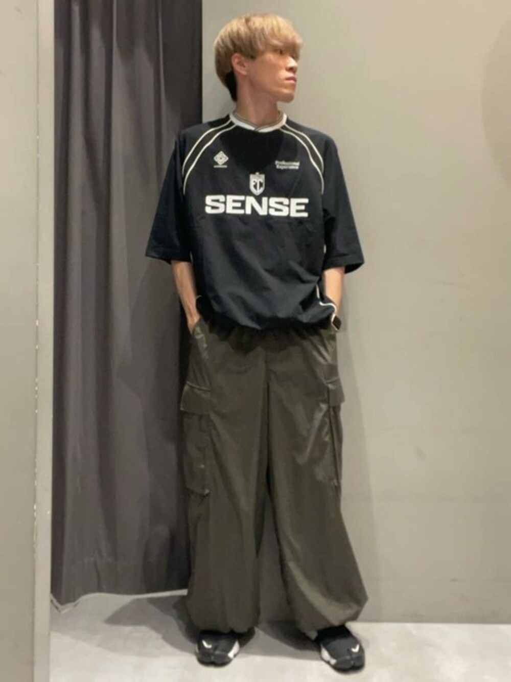 ブラック系のTシャツ/カットソー、グリーン系のカーゴパンツを着用したメンズの秋コーディネートの1枚目の写真