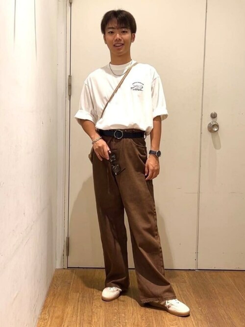 ホワイト系のTシャツ/カットソー、ブラウン系のチノパンツを着用したメンズの秋コーディネートの1枚目の写真