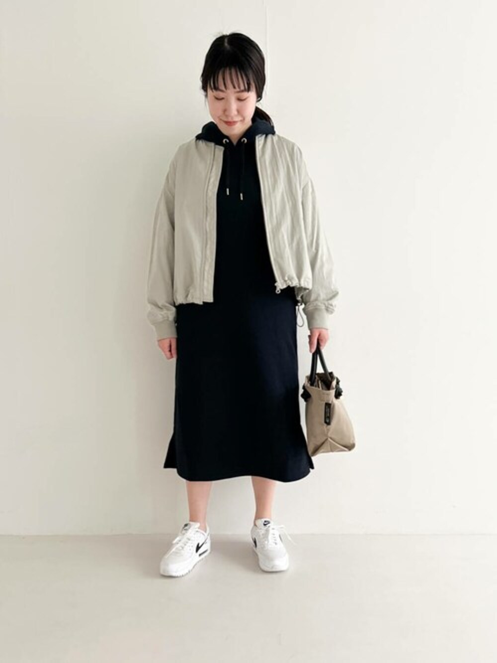 ベージュ系のブルゾン、ブルー系のワンピース、ベージュ系のトートバッグを着用したレディースの春コーディネートの1枚目の写真