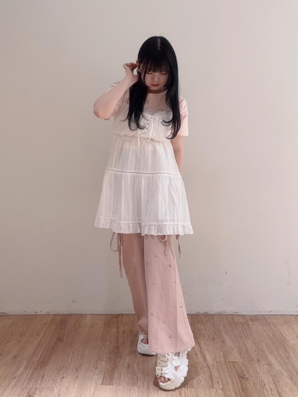 ピンク系のデニムパンツ、ホワイト系のサンダル、ホワイト系のワンピースを着用したレディースの春コーディネートの1枚目の写真