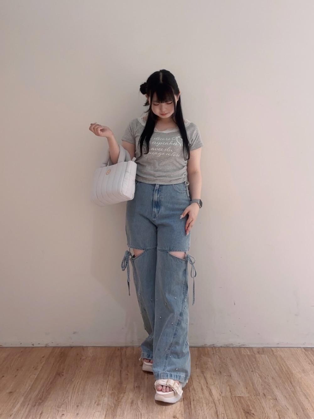 ブルー系のデニムパンツ、ブルー系のショルダーバッグ、ホワイト系のサンダルを着用したレディースの夏コーディネートの1枚目の写真