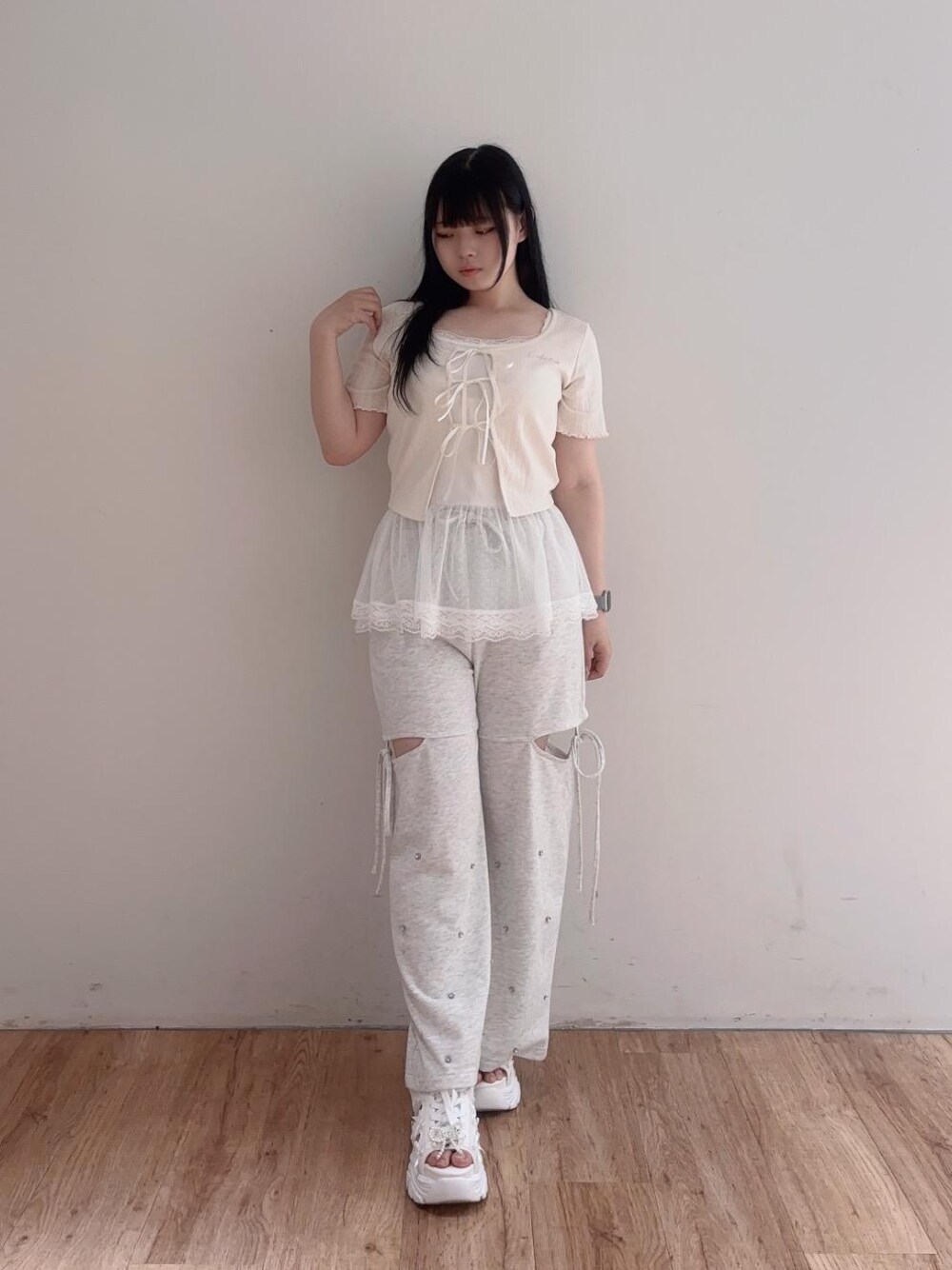 ホワイト系のサンダル、ホワイト系のTシャツ/カットソー、ベージュ系のスウェットパンツを着用したレディースの夏コーディネートの1枚目の写真