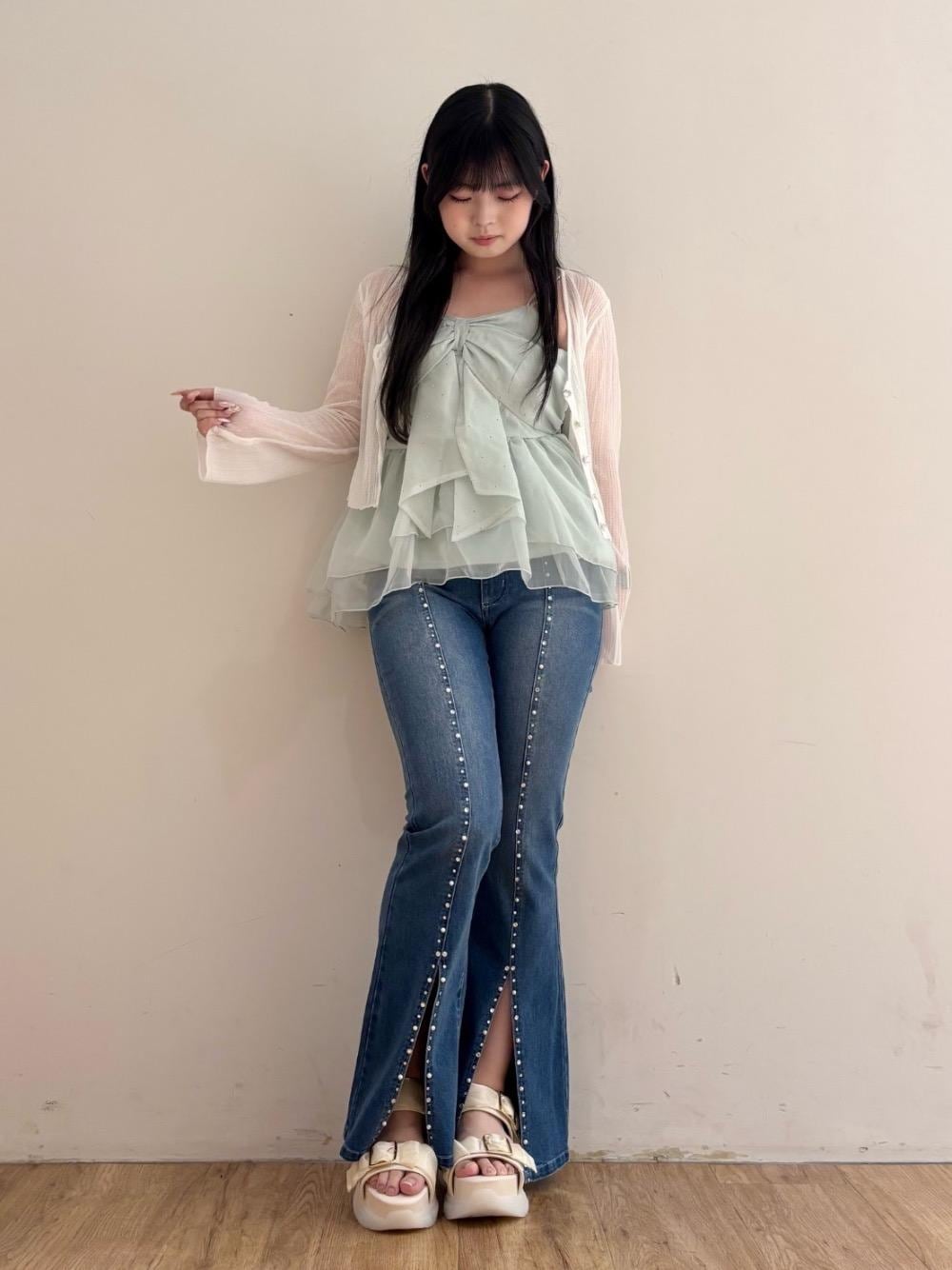 ホワイト系のサンダル、ホワイト系のニット/セーター、ブルー系のデニムパンツを着用したレディースの夏コーディネートの1枚目の写真