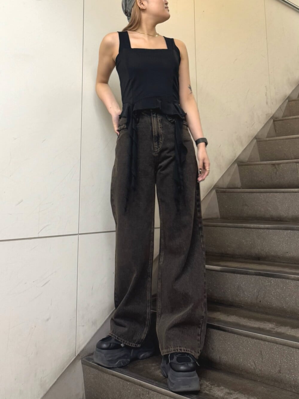 ブラック系のスニーカー、ブラック系のTシャツ/カットソー、ブラック系のデニムパンツを着用したレディースの春コーディネートの1枚目の写真