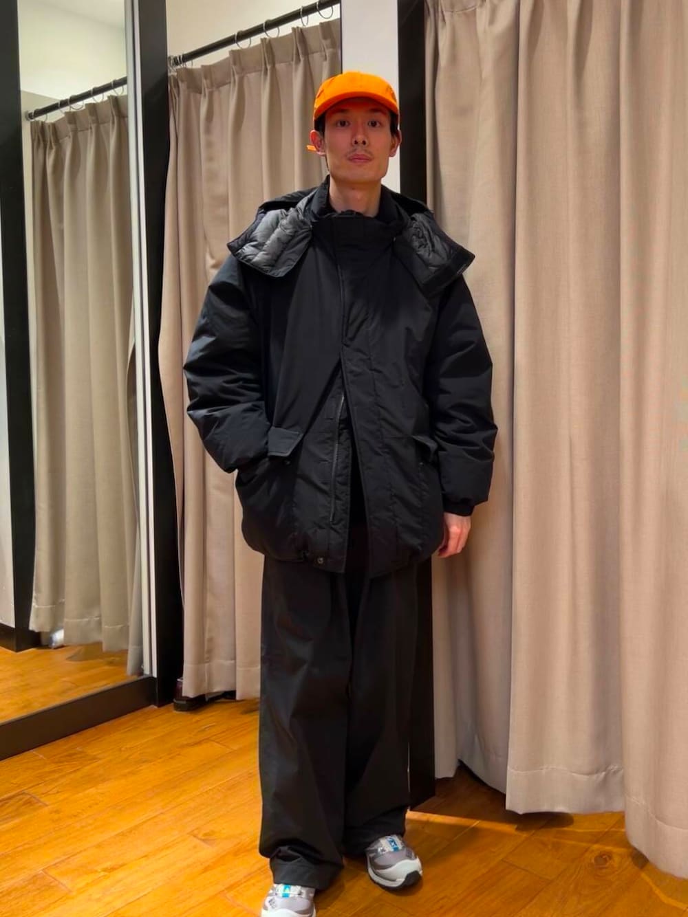 ブラック系のダウンジャケット/コート、シルバー系のスニーカー、ブルー系のニット/セーターを着用したメンズの冬コーディネートの1枚目の写真