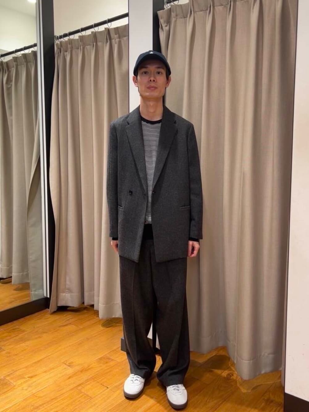 ホワイト系のニット/セーター、グレー系のスニーカー、グレー系のスラックスを着用したメンズの秋コーディネートの1枚目の写真