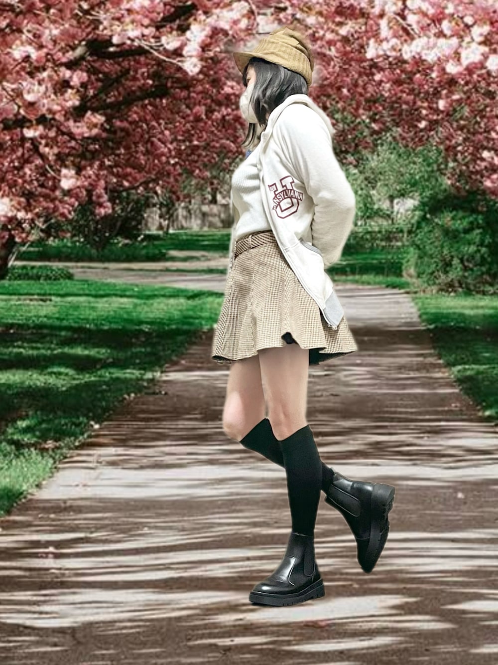 グレー系のパーカー、ベージュ系のスカート、ブラック系のブーツを着用したレディースの春コーディネートの1枚目の写真