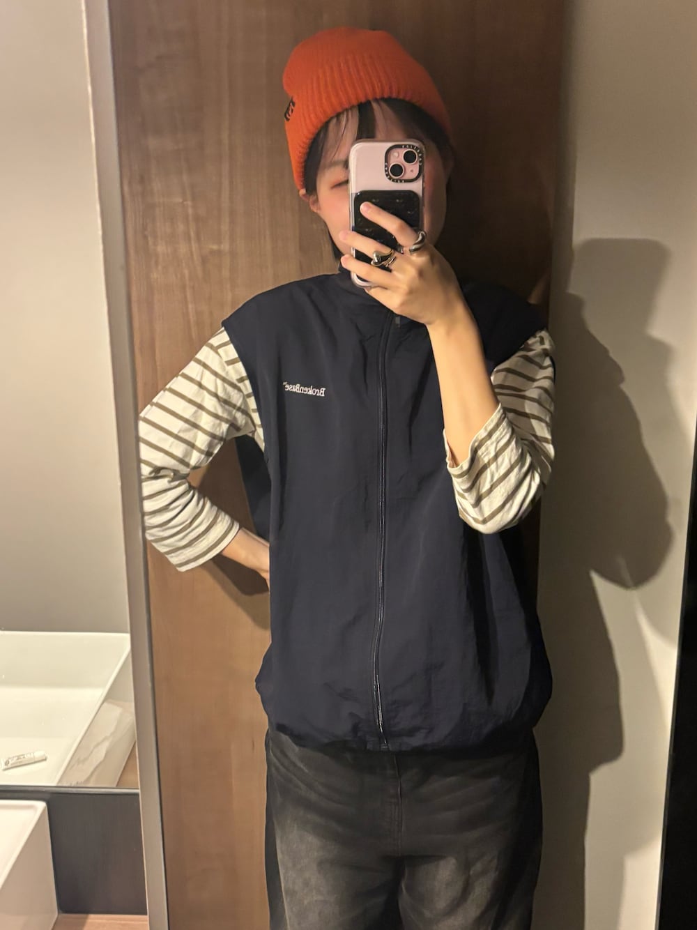 ブラック系のデニムパンツ、ブルー系のベスト、ホワイト系のTシャツ/カットソーを着用したレディースの秋コーディネートの1枚目の写真