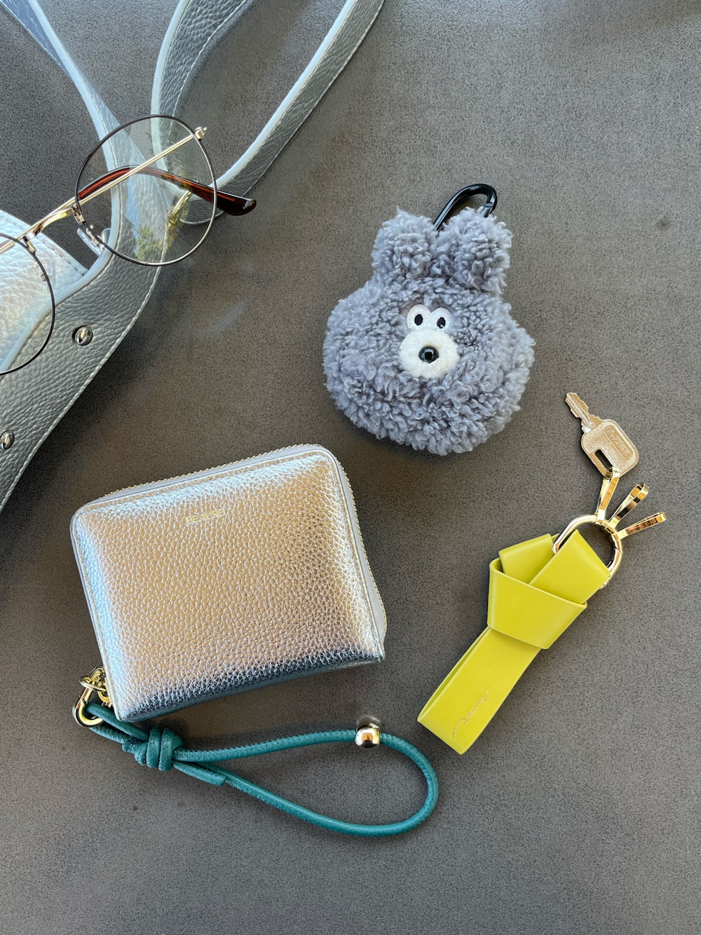 シルバー系のショルダーバッグ、グレー系のヘッドフォン/イヤホン、シルバー系の財布を着用したレディースの夏コーディネートの1枚目の写真