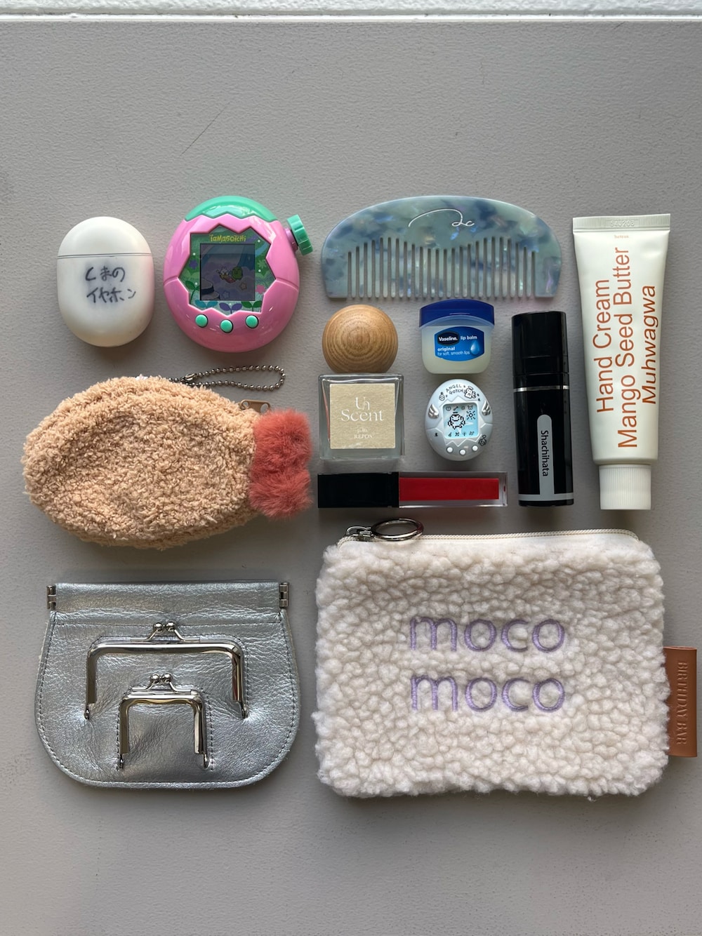 ホワイト系のポーチ、シルバー系の財布、イエロー系のインテリア雑貨を着用したレディースの冬コーディネートの1枚目の写真