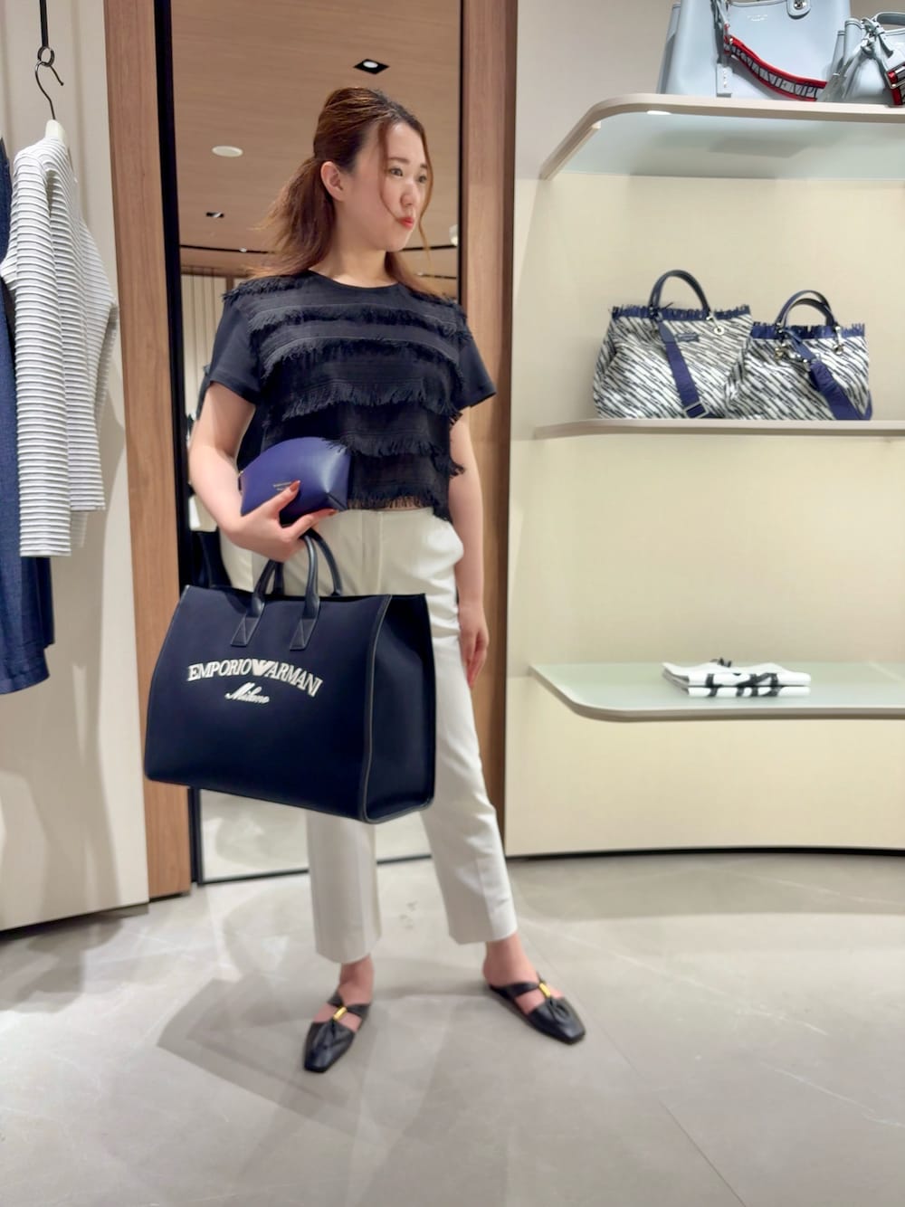 ホワイト系のTシャツ/カットソー、ブルー系のトートバッグ、パープル系のポーチを着用したレディースの夏コーディネートの1枚目の写真