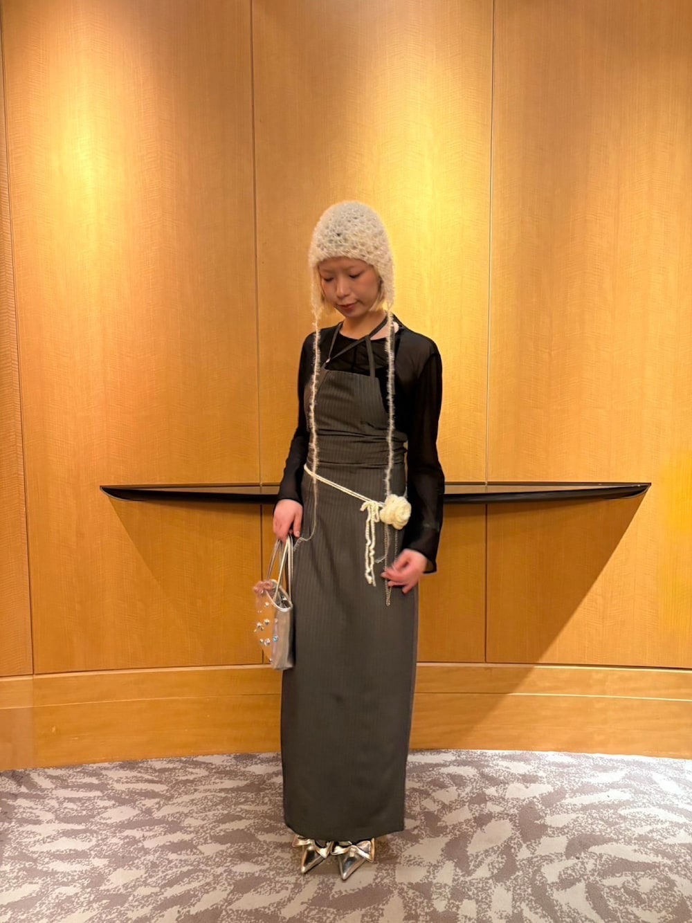 グレー系のワンピース、シルバー系のパンプス、シルバー系のバッグを着用したレディースの冬コーディネートの1枚目の写真