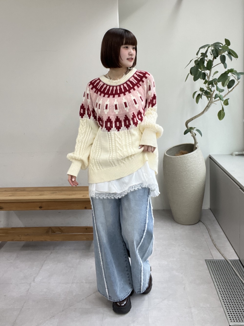 ブルー系のデニムパンツ、レッド系のニット/セーター、ブラウン系のその他シューズを着用したレディースの冬コーディネートの1枚目の写真