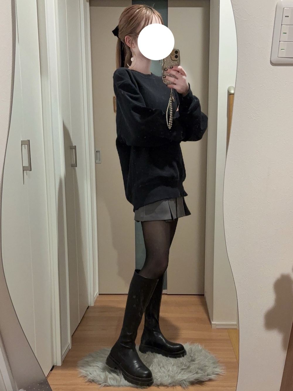 ブラック系のブーツ、グレー系のスカート、ブラック系のスウェットを着用したレディースの秋コーディネートの1枚目の写真