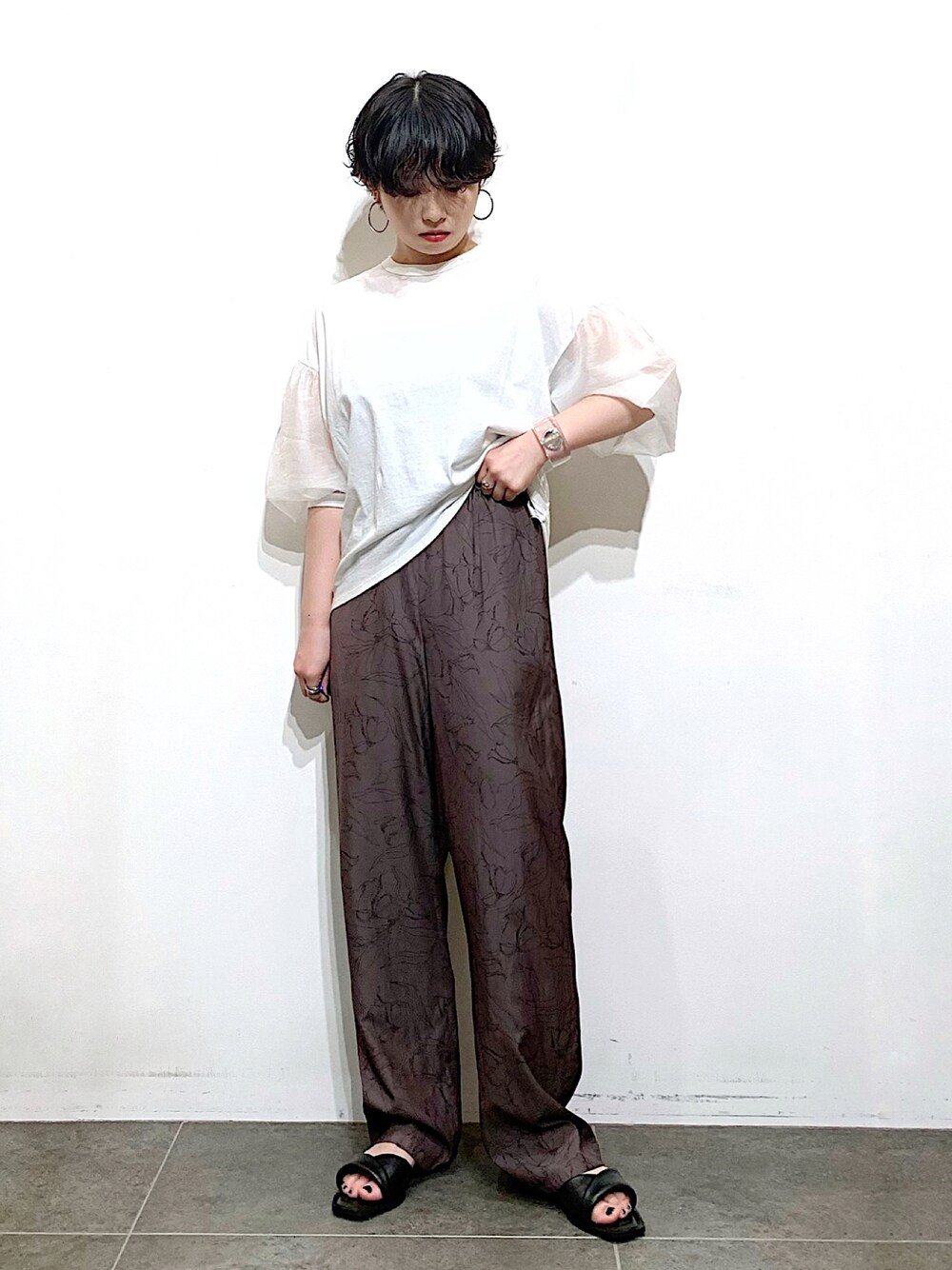 ブラック系のサンダル、ブラウン系のその他パンツ、ホワイト系のTシャツ/カットソーを着用したレディースの夏コーディネートの1枚目の写真