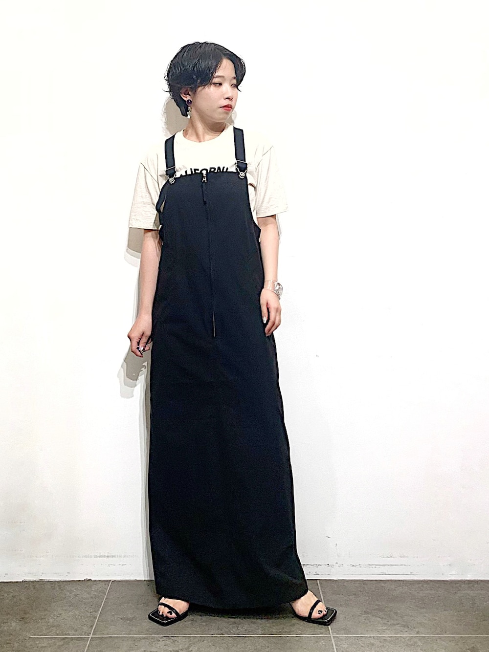 ブラック系のサンダル、ホワイト系のTシャツ/カットソー、ブラック系のワンピース/ドレスを着用したレディースの夏コーディネートの1枚目の写真