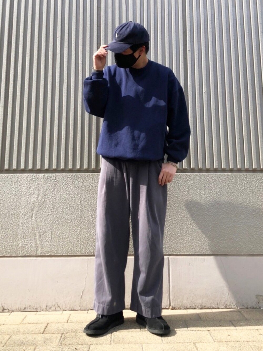 ブラック系のブーツ、グレー系のチノパンツ、ブルー系のスウェットを着用したメンズの春コーディネートの1枚目の写真