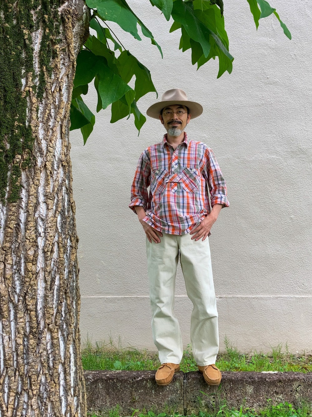 オレンジ系のシャツ/ブラウス、ホワイト系のデニムパンツ、ベージュ系のモカシン/デッキシューズを着用したメンズの夏コーディネートの1枚目の写真