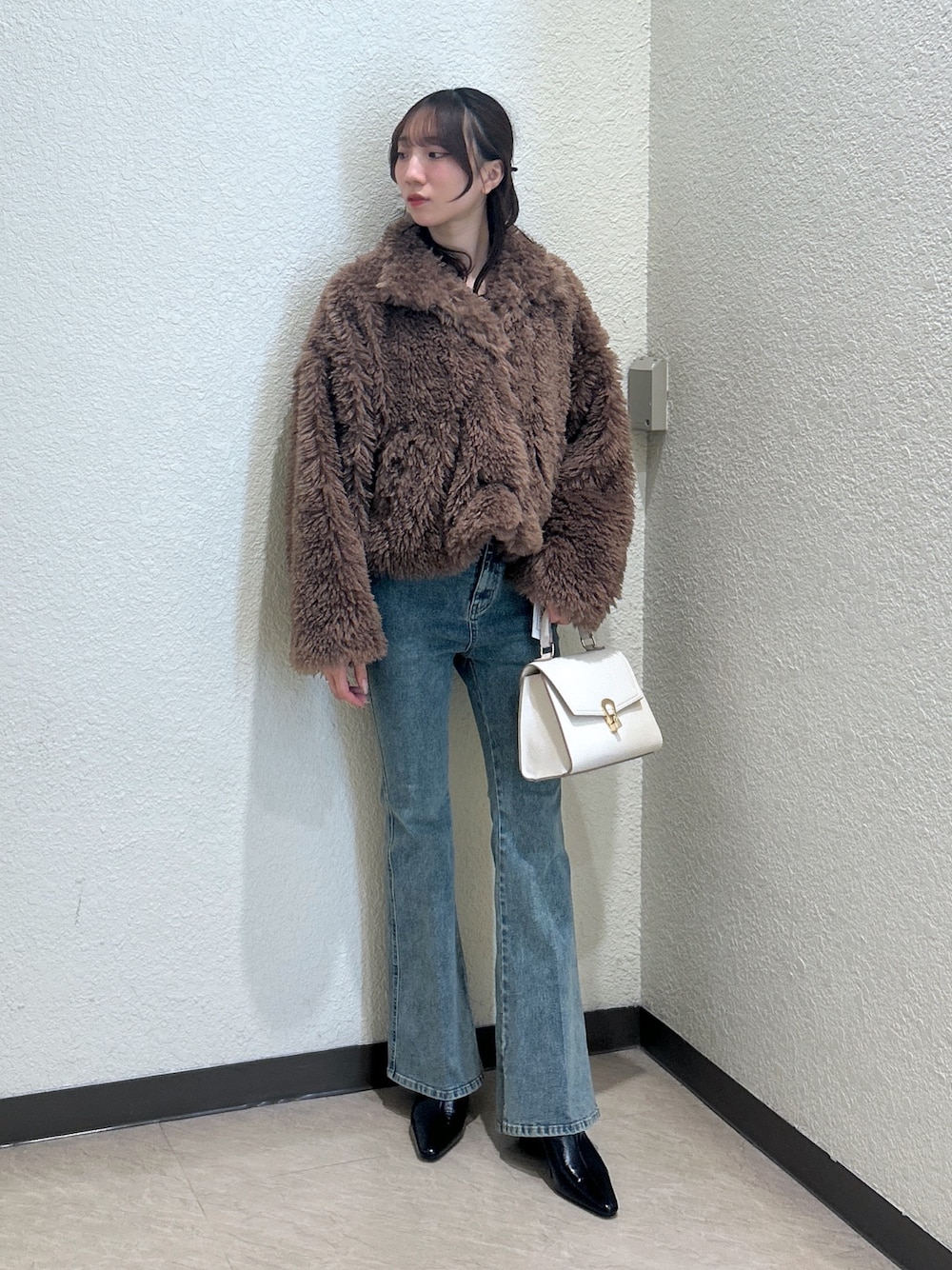 ホワイト系のトートバッグ、ブルー系のデニムパンツ、ブラック系のパンプスを着用したレディースの秋コーディネートの1枚目の写真