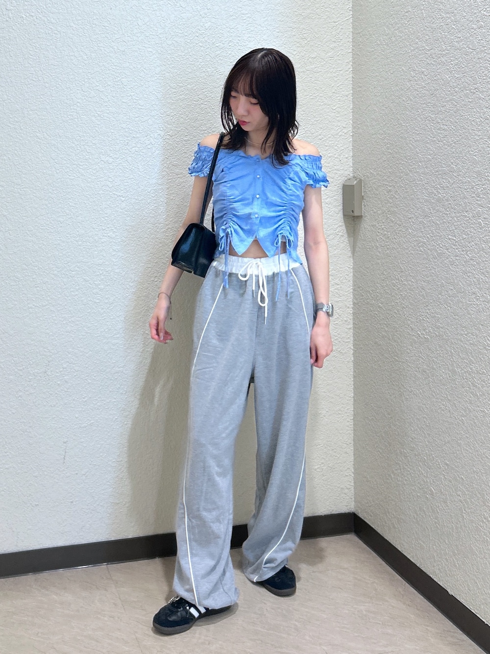 ブルー系のシャツ/ブラウス、ブラック系のショルダーバッグを着用したレディースの夏コーディネートの1枚目の写真