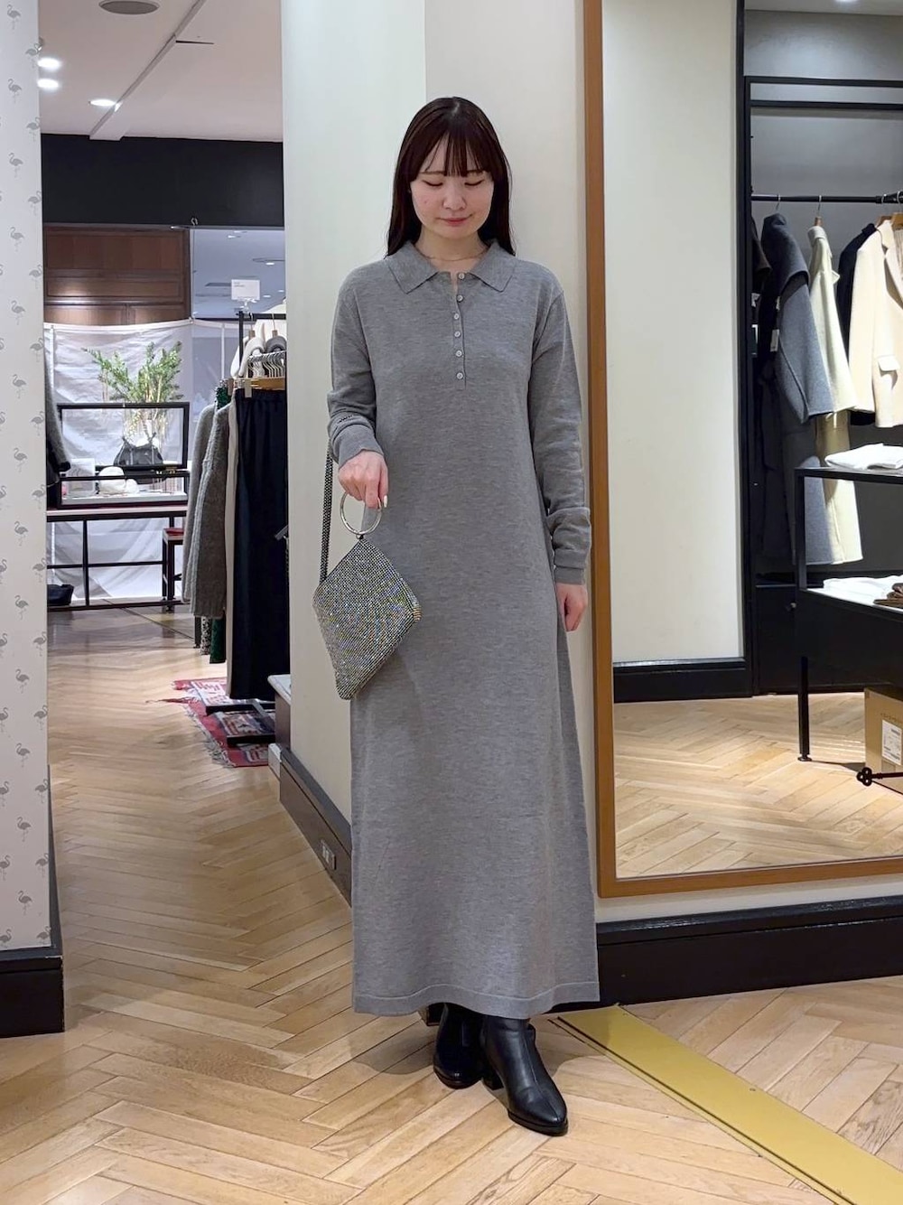 ブラック系のブーツ、グレー系のワンピース、シルバー系のショルダーバッグを着用したレディースの冬コーディネートの1枚目の写真