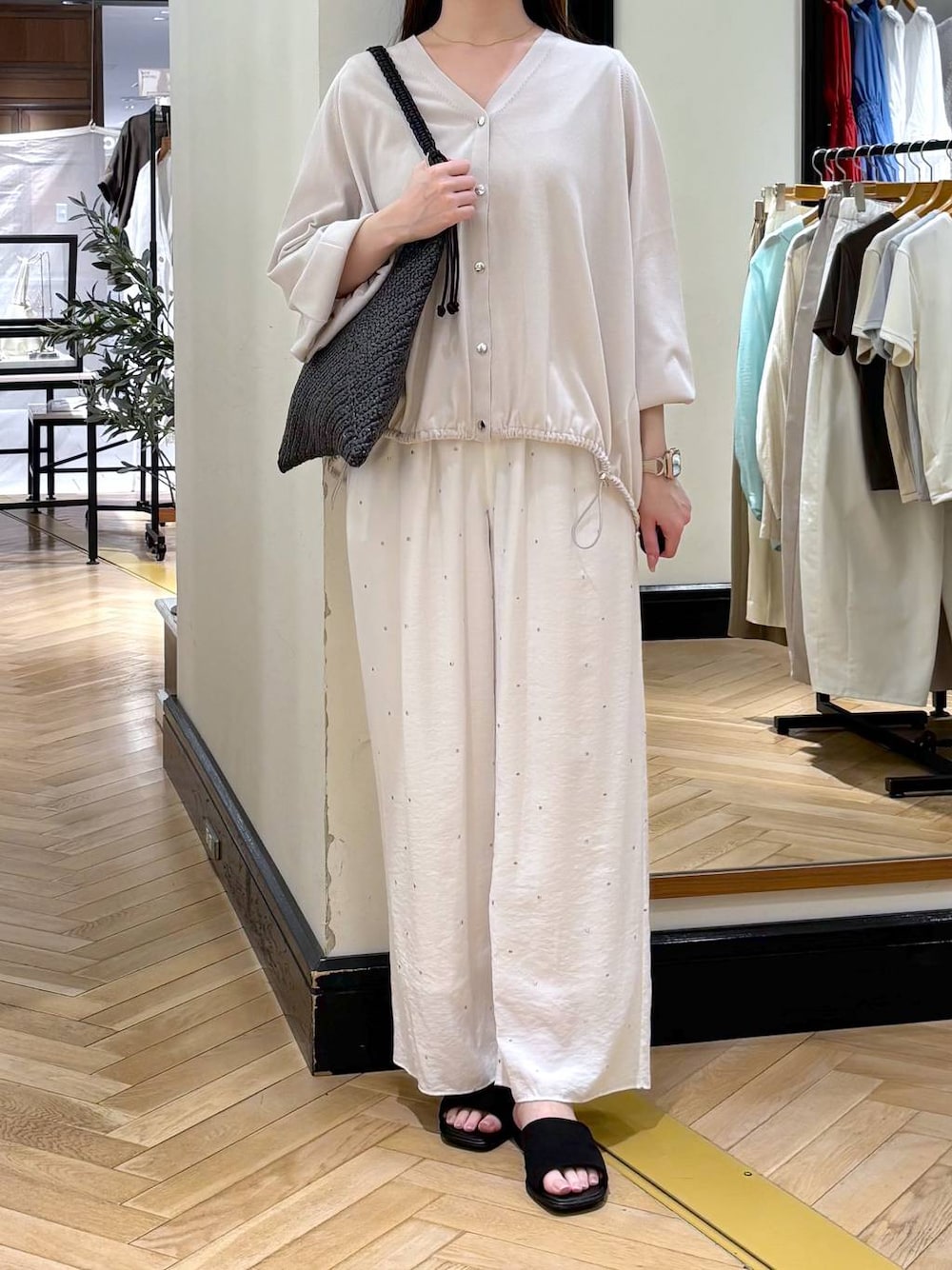 グレー系のカーディガン/ボレロ、ホワイト系のその他パンツ、ブラック系のサンダルを着用したレディースの春コーディネートの1枚目の写真