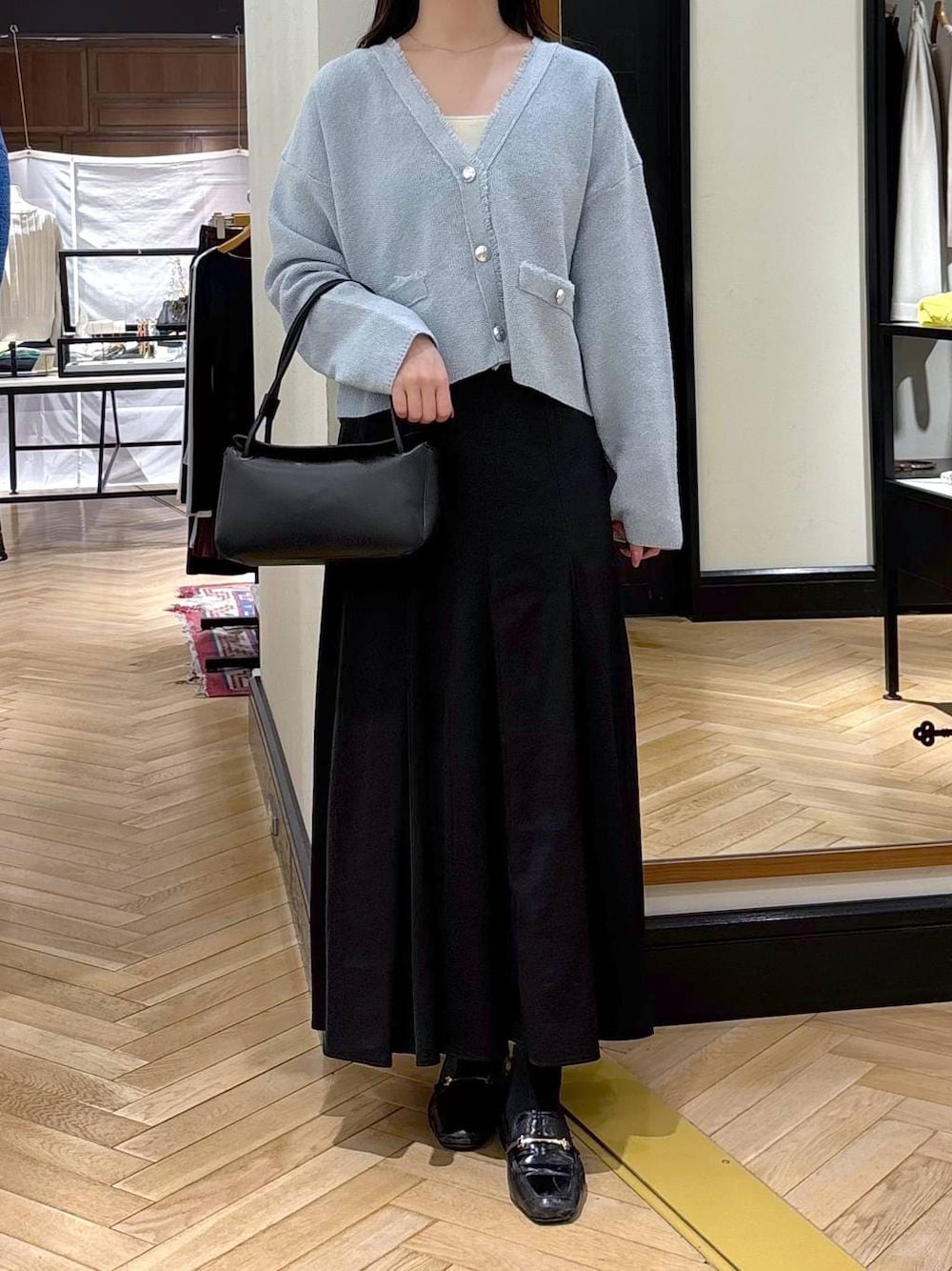 ブラック系のローファー、ブルー系のカーディガン/ボレロ、ブラック系のショルダーバッグを着用したレディースの春コーディネートの1枚目の写真